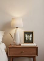 Dark Gothic Moth Illustration art print shown in a small bedside oak setting