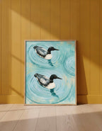 Common Loon Pair Painting art print shown in a yellow wall setting